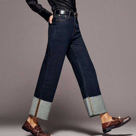 Femme portant un jean droit en denim brut avec grands revers contrastés en bas de jambe – modèle taille haute tendance et moderne proposé par Luxorel