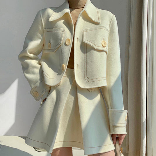  Femme portant un ensemble blanc structuré – veste courte avec grandes poches et jupe taille haute évasée